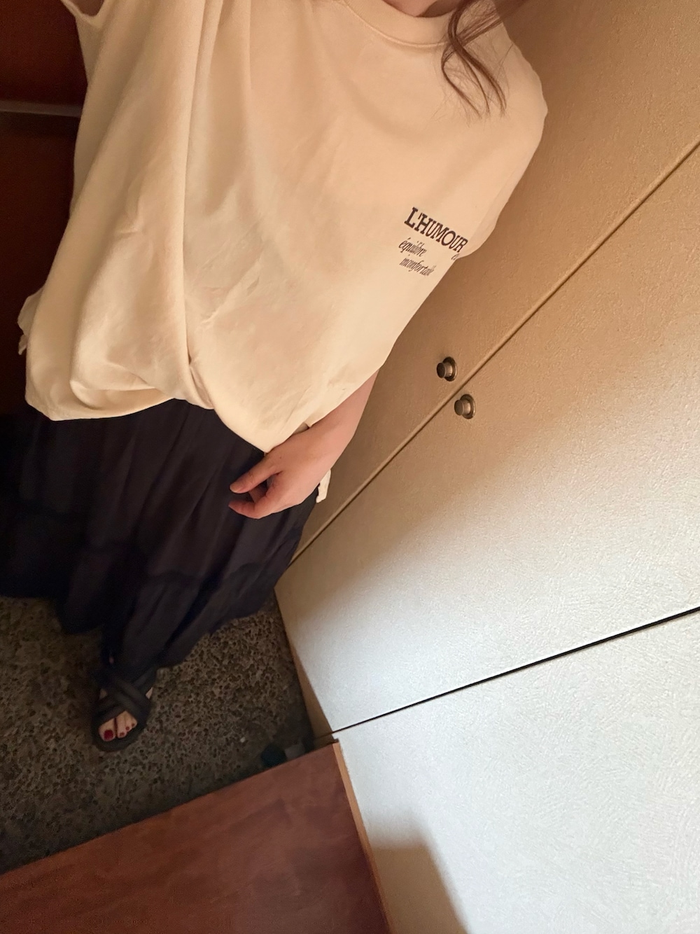 ホワイト系のTシャツ/カットソー、ブラック系のスカート、ブラウン系のサンダルを着用したレディースの夏コーディネートの1枚目の写真