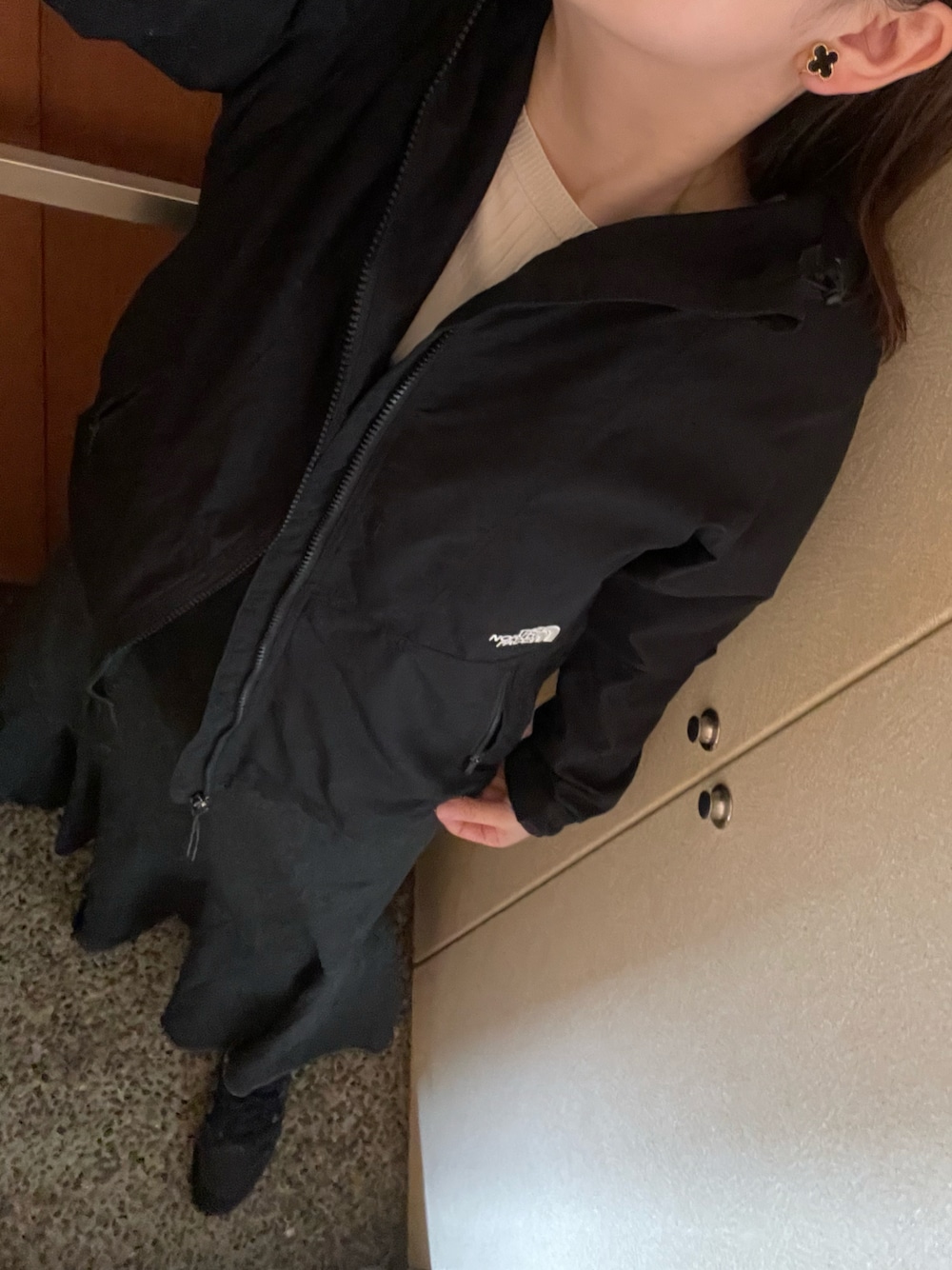 ブラック系のブルゾン、ホワイト系のニット/セーター、ブラック系のスニーカーを着用したレディースの春コーディネートの1枚目の写真