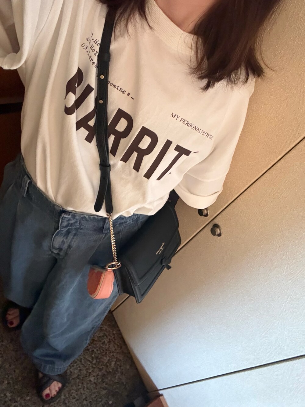 ホワイト系のTシャツ/カットソー、ブルー系のデニムパンツ、ブラック系のショルダーバッグを着用したレディースの夏コーディネートの1枚目の写真