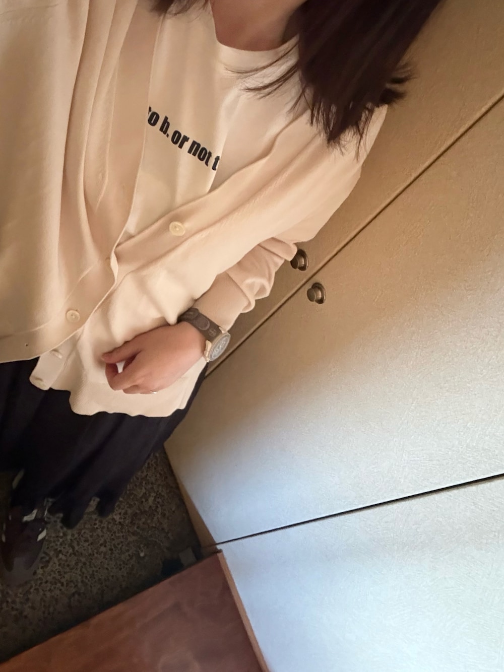 ホワイト系のTシャツ/カットソー、ホワイト系のカーディガン/ボレロ、ブラック系のスカートを着用したレディースの春コーディネートの1枚目の写真
