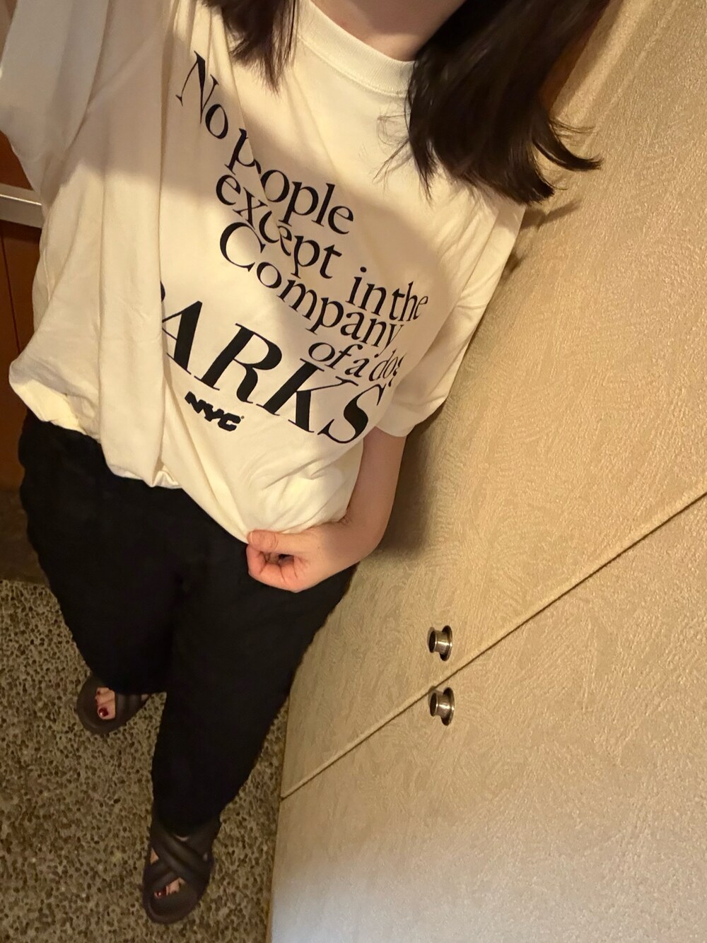 ホワイト系のTシャツ/カットソー、ブラック系のその他パンツ、ブラウン系のサンダルを着用したレディースの秋コーディネートの1枚目の写真