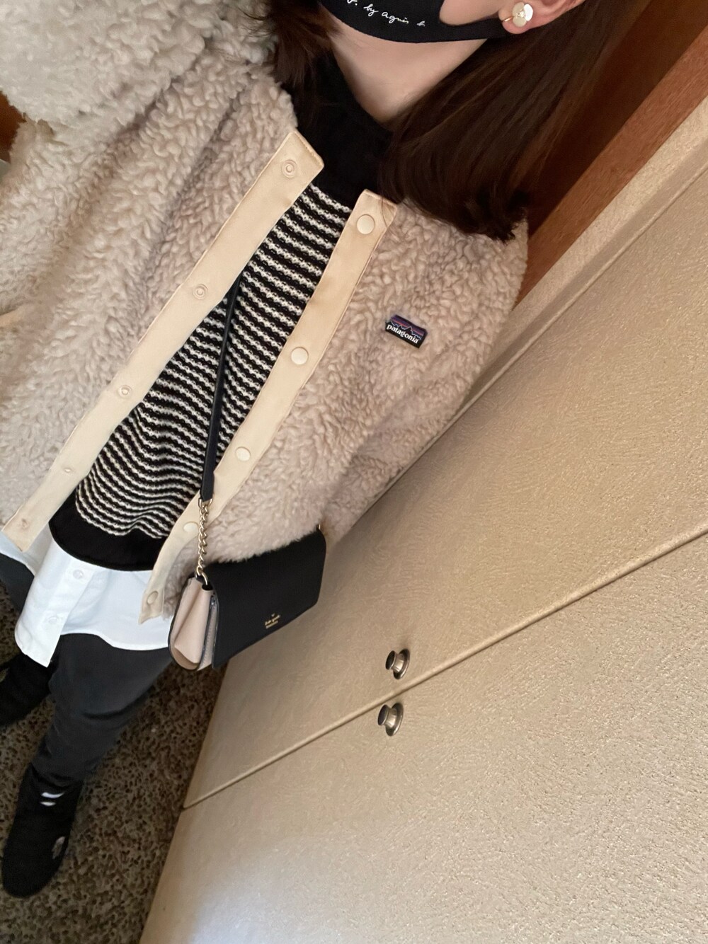 ベージュ系のブルゾン、ブラック系のニット/セーター、グレー系のデニムパンツを着用したレディースの冬コーディネートの1枚目の写真