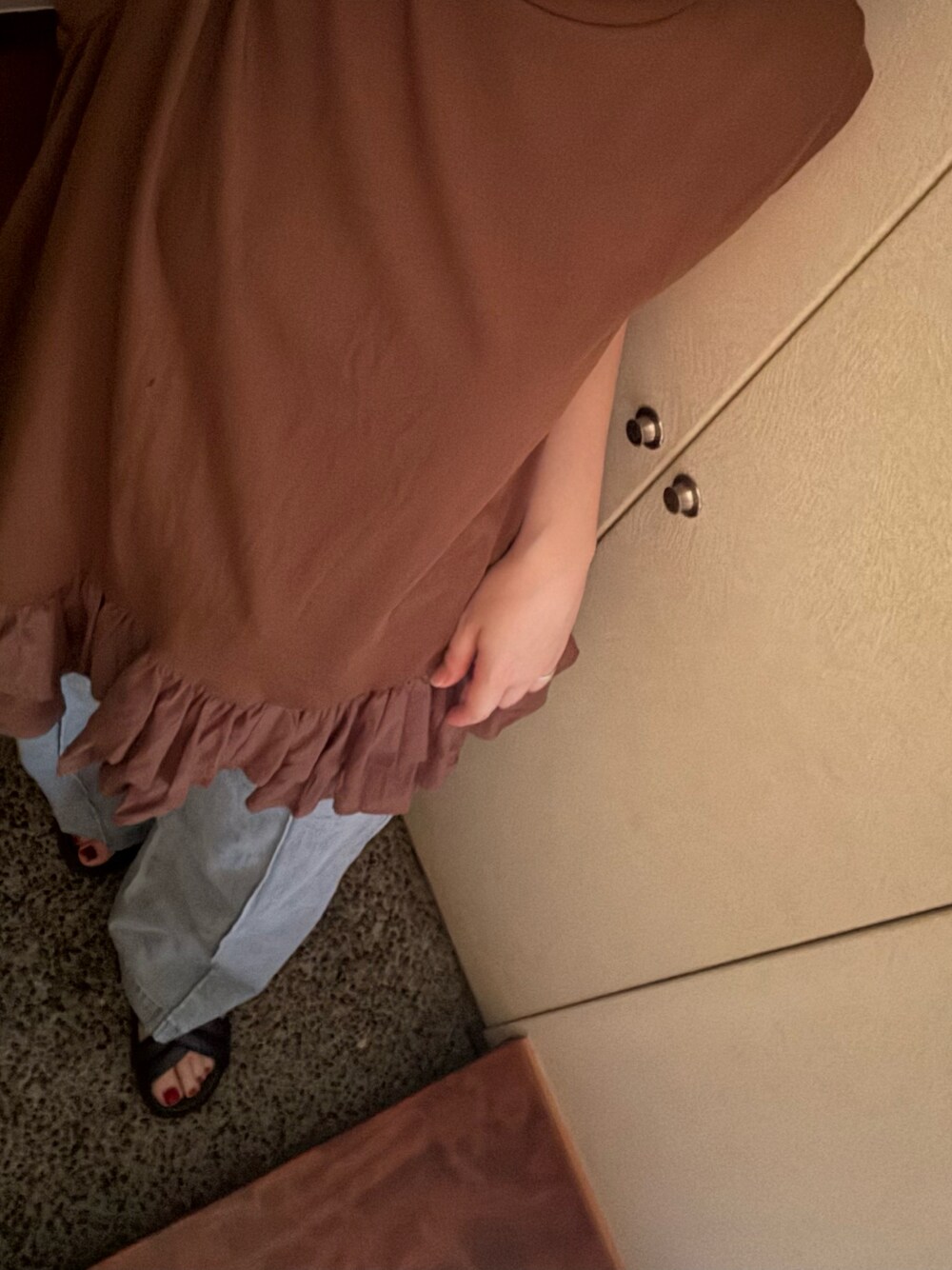 ブラウン系のチュニック、ブルー系のデニムパンツ、ブラウン系のサンダルを着用したレディースの夏コーディネートの1枚目の写真