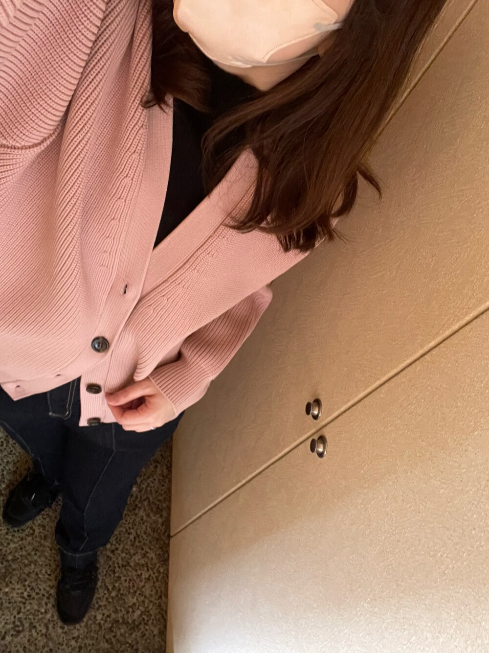 ブラック系のニット/セーター、ピンク系のカーディガン/ボレロ、ブルー系のデニムパンツを着用したレディースの春コーディネートの1枚目の写真