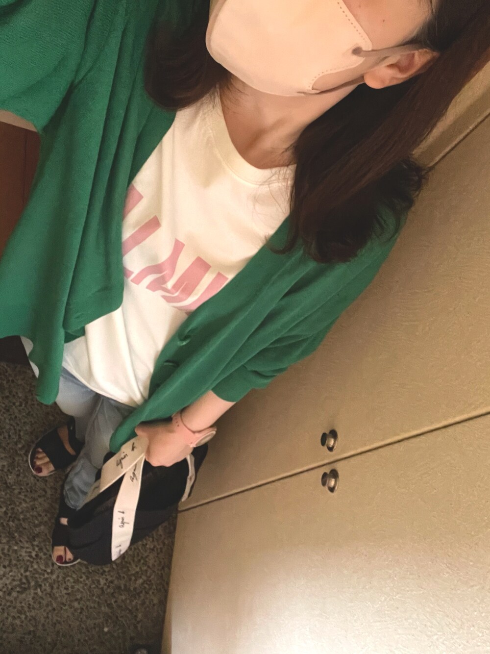 ブラック系のトートバッグ、ピンク系のTシャツ/カットソー、ブラック系のサンダルを着用したレディースの春コーディネートの1枚目の写真