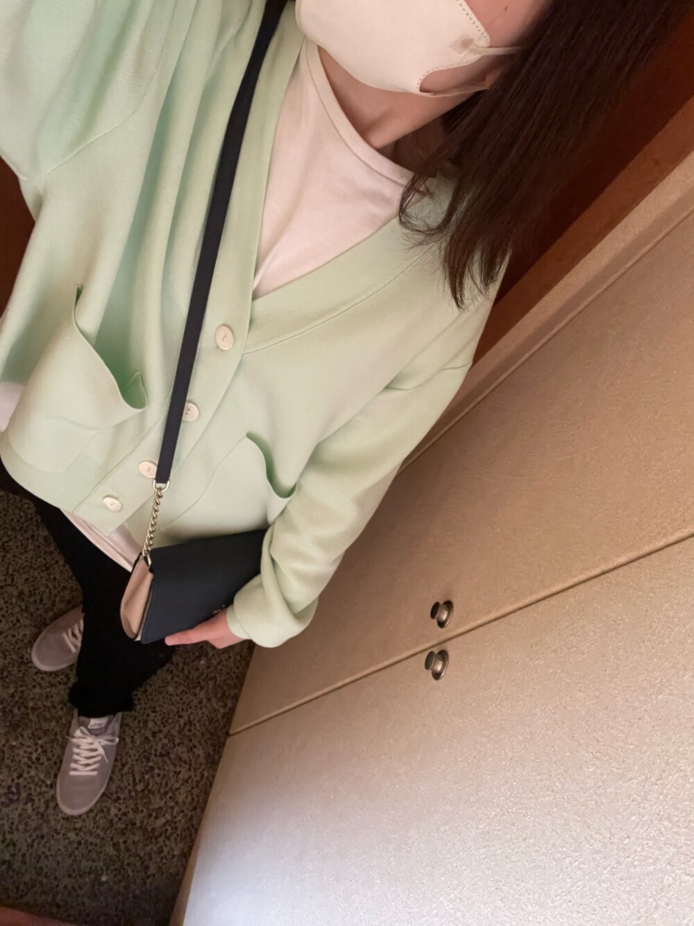 グリーン系のカーディガン/ボレロ、グレー系のスニーカーを着用したレディースの春コーディネートの1枚目の写真