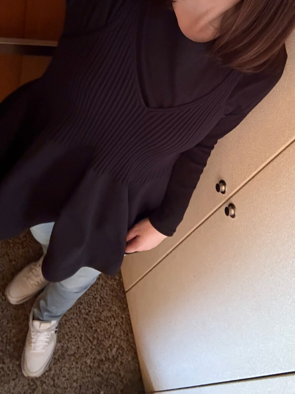 ホワイト系のTシャツ/カットソー、ブラック系のニット/セーター、ブルー系のデニムパンツを着用したレディースの春コーディネートの1枚目の写真