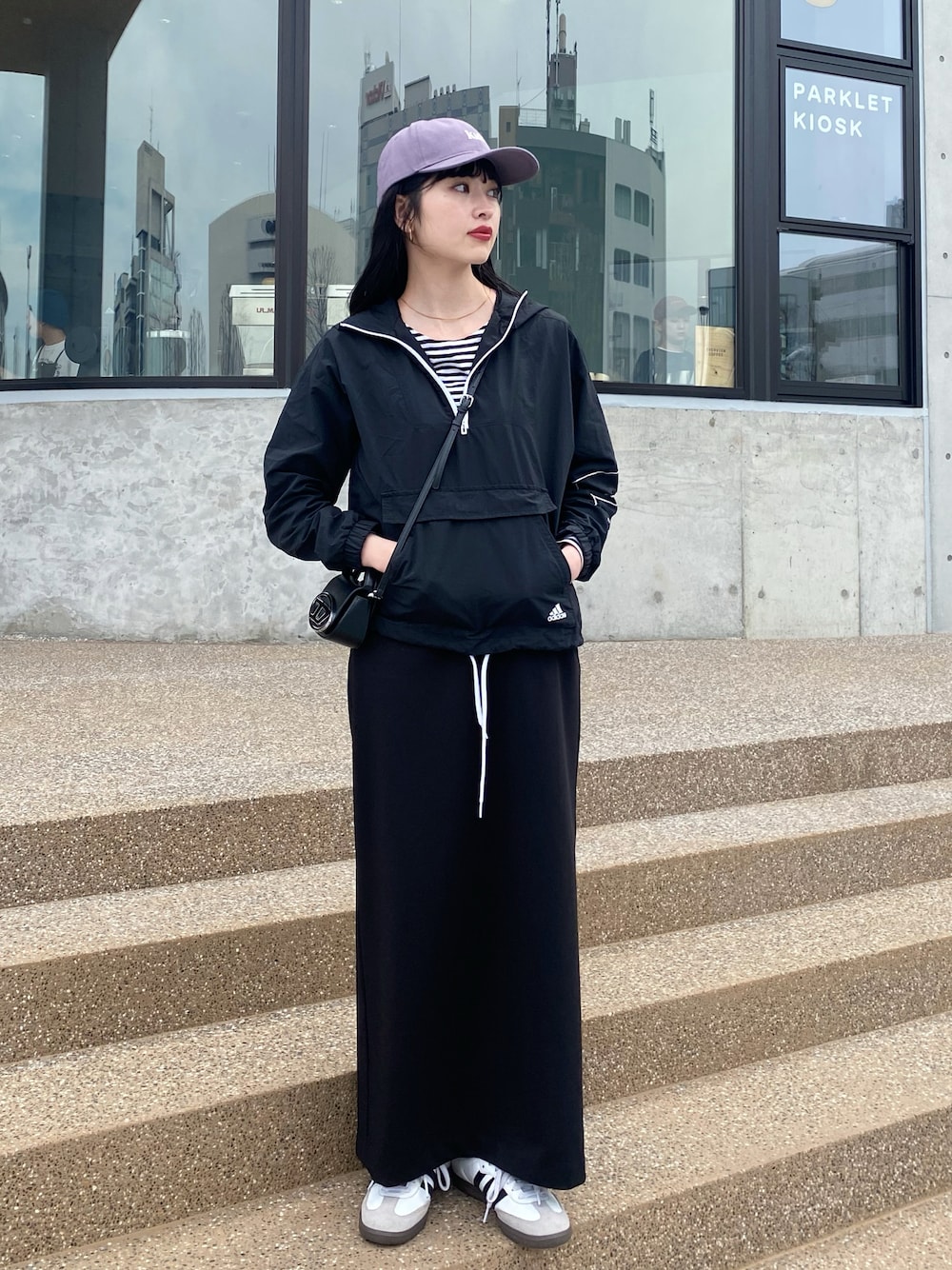 ブラック系のスニーカー、ブラック系のトップス、ブラック系のショルダーバッグを着用したレディースの春コーディネートの1枚目の写真