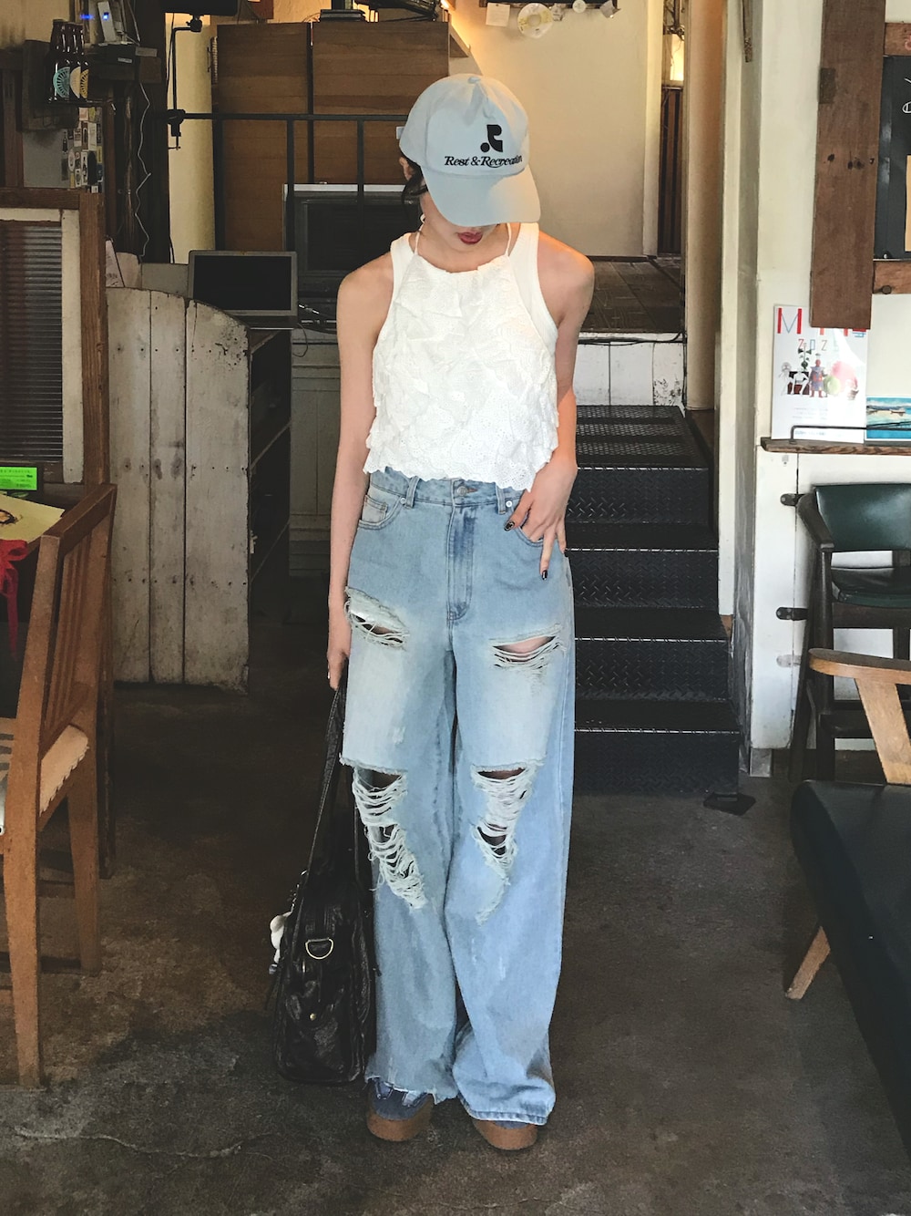 ブルー系のデニムパンツ、ブルー系のキャップを着用したレディースの夏コーディネートの1枚目の写真