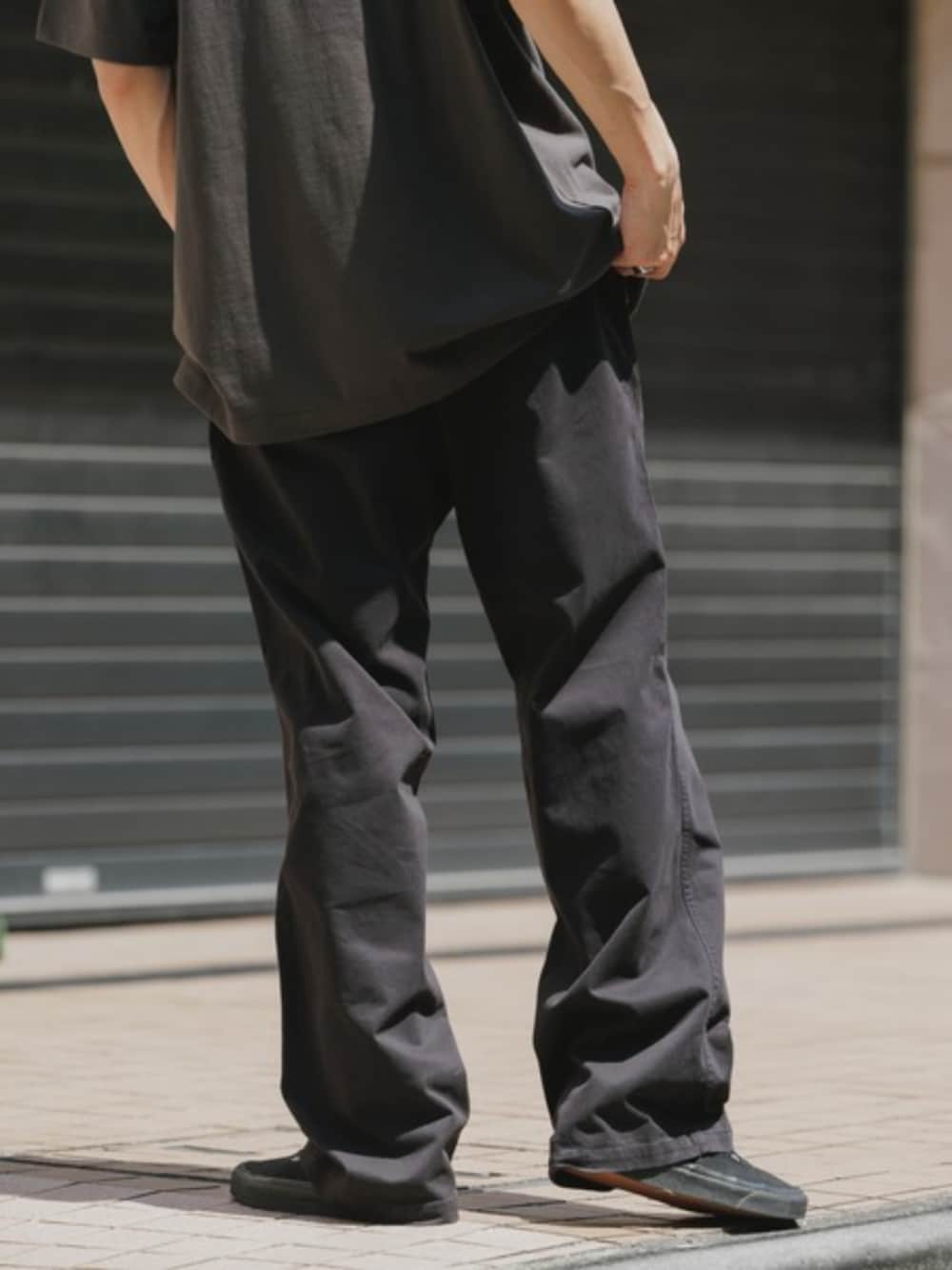 ブラック系のチノパンツ、ブラック系のTシャツ/カットソーを着用したメンズの夏コーディネートの1枚目の写真