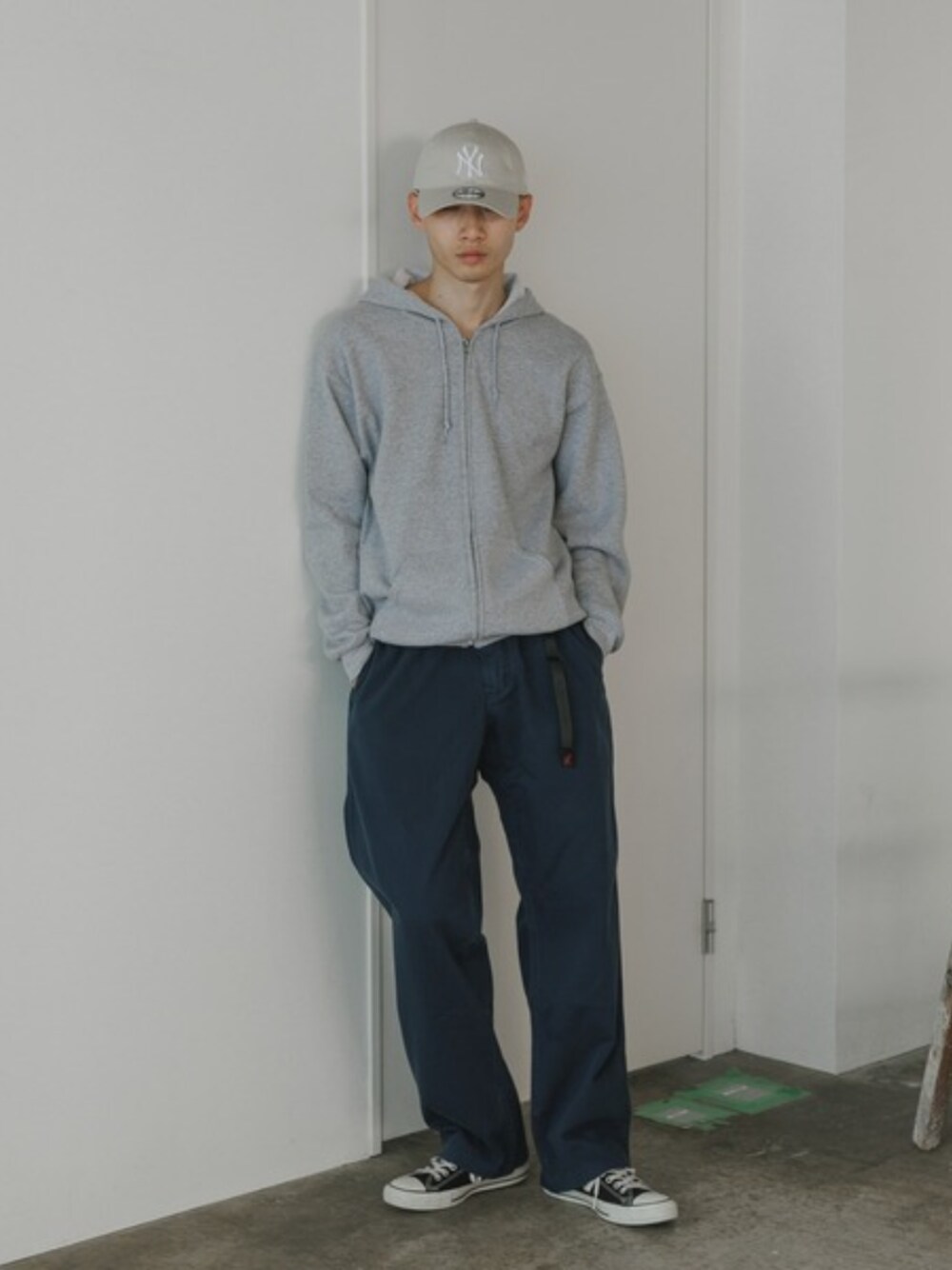 ホワイト系のタンクトップ、ブルー系のチノパンツ、グレー系のパーカーを着用したメンズの夏コーディネートの1枚目の写真