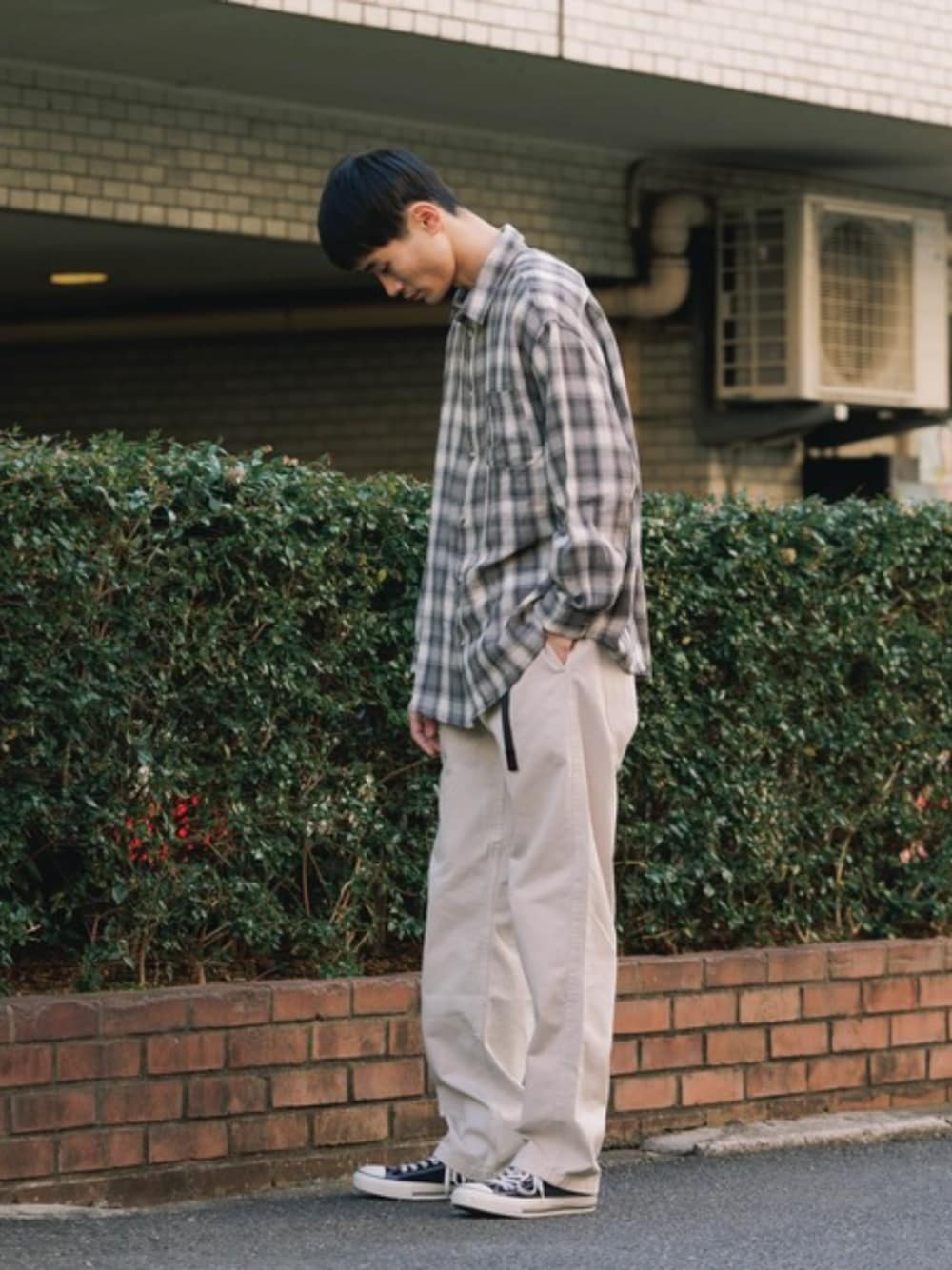 ホワイト系のタンクトップ、ベージュ系のチノパンツを着用したメンズの夏コーディネートの1枚目の写真