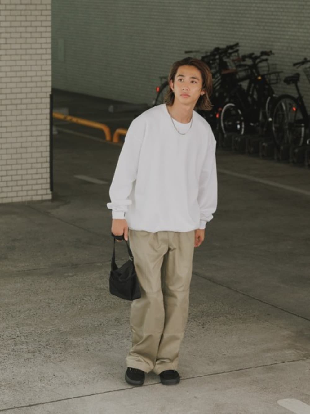 グリーン系のチノパンツ、ホワイト系のTシャツ/カットソー、ブラック系のショルダーバッグを着用したメンズの夏コーディネートの1枚目の写真