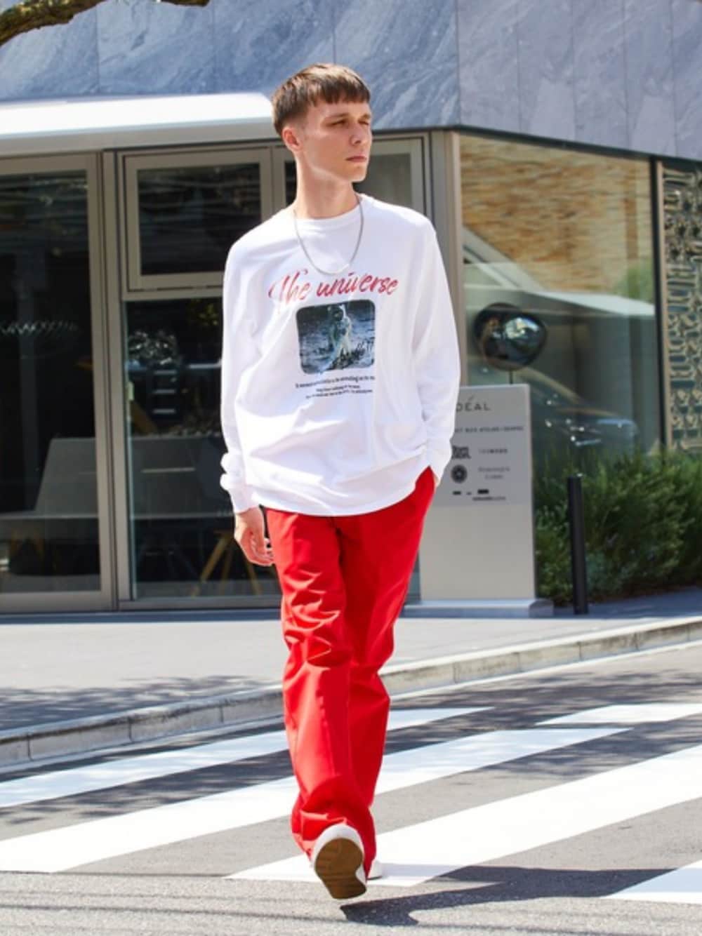 レッド系のチノパンツ、ホワイト系のTシャツ/カットソー、グレー系のスニーカーを着用したメンズの夏コーディネートの1枚目の写真