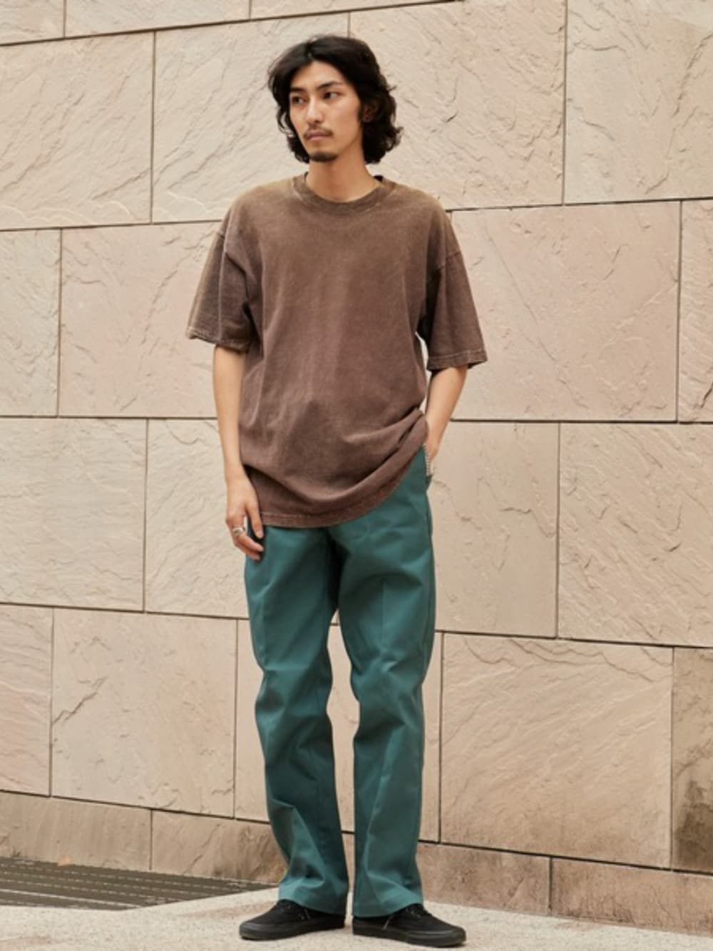 ブラック系のスニーカー、グリーン系のチノパンツ、ブラウン系のTシャツ/カットソーを着用したメンズの夏コーディネートの1枚目の写真
