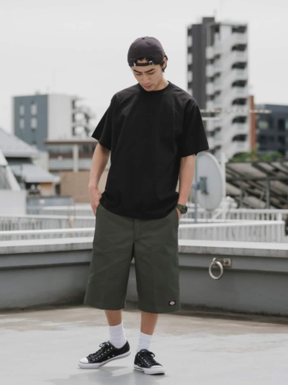 グリーン系のチノパンツ、ブラック系のTシャツ/カットソー、ホワイト系のソックス/靴下を着用したメンズの夏コーディネートの1枚目の写真