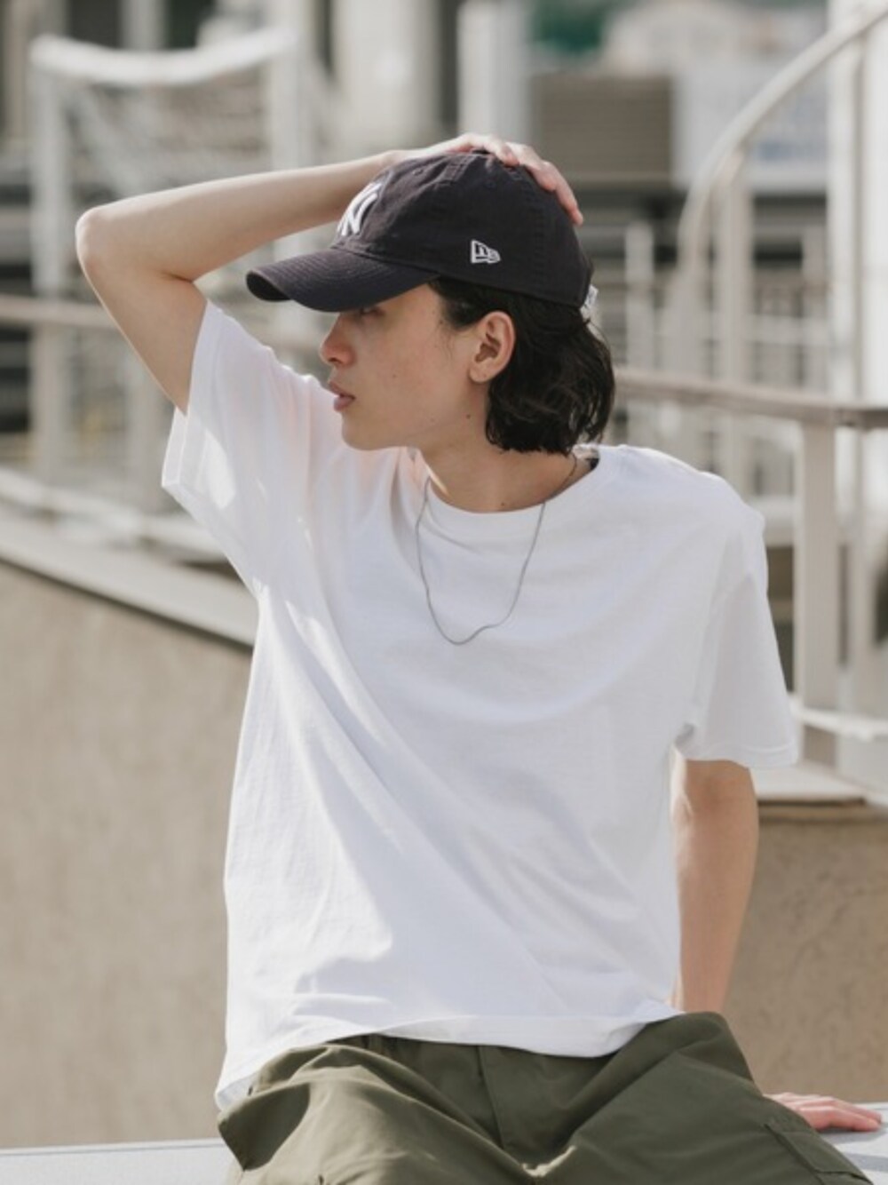 ブラック系のカーゴパンツ、ホワイト系のTシャツ/カットソーを着用したメンズの夏コーディネートの1枚目の写真