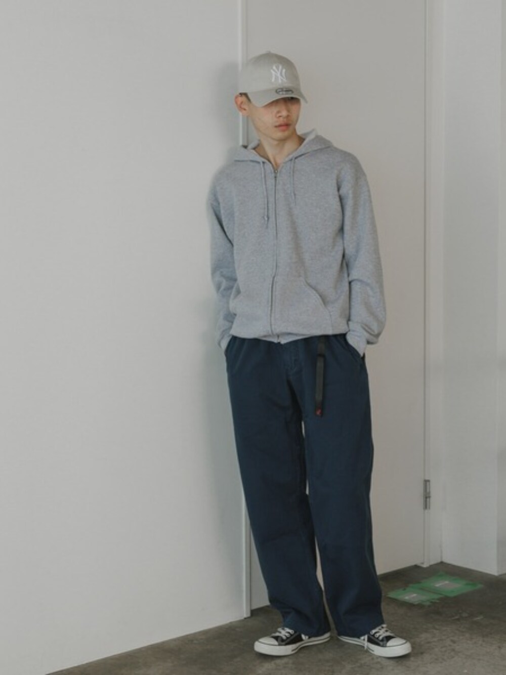 ホワイト系のタンクトップ、ブルー系のチノパンツ、グレー系のパーカーを着用したメンズの夏コーディネートの1枚目の写真