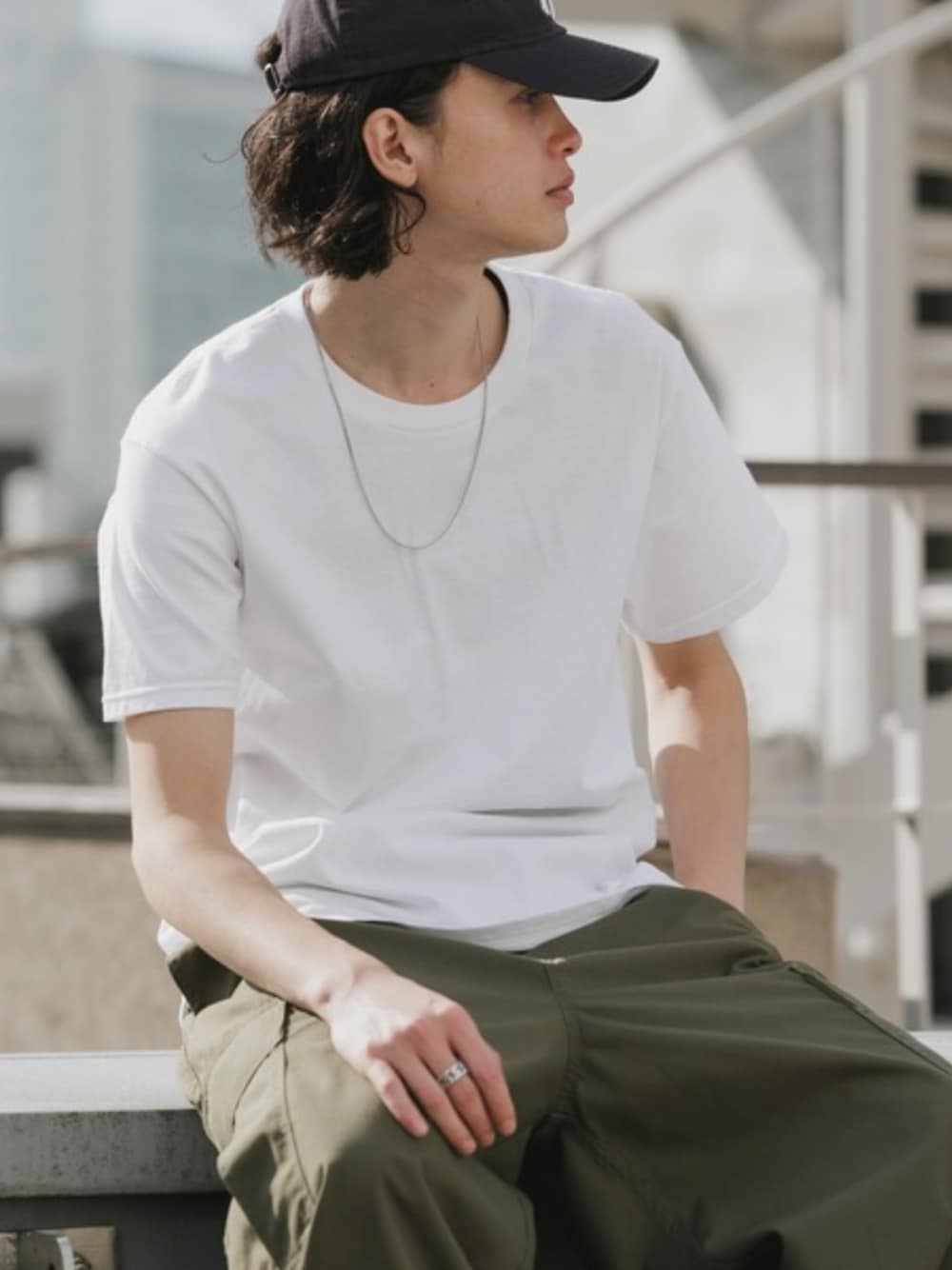 ブラック系のカーゴパンツ、ホワイト系のTシャツ/カットソーを着用したメンズの夏コーディネートの1枚目の写真