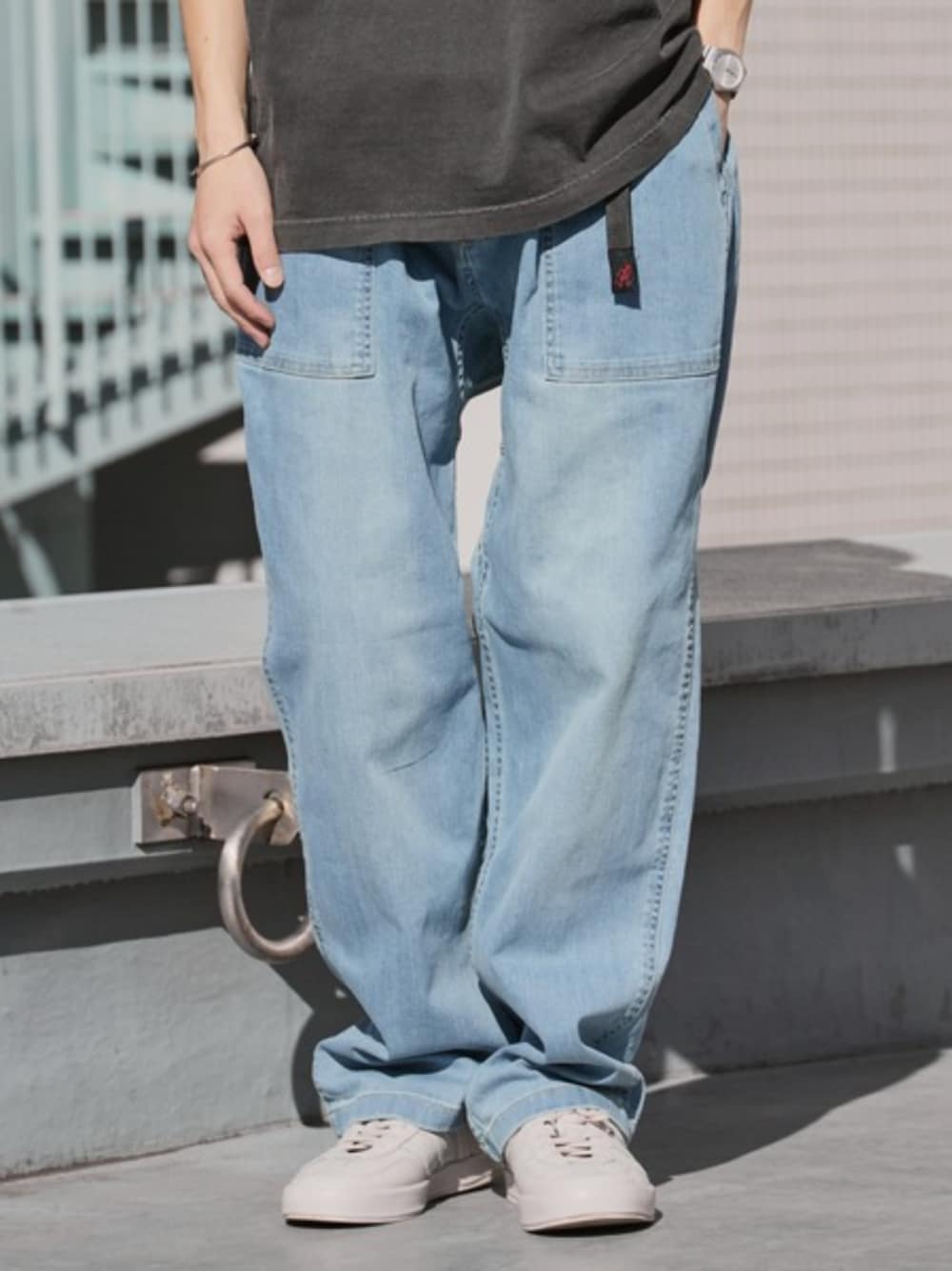 ブルー系のデニムパンツ、グレー系のTシャツ/カットソー、ベージュ系のスニーカーを着用したメンズの夏コーディネートの1枚目の写真