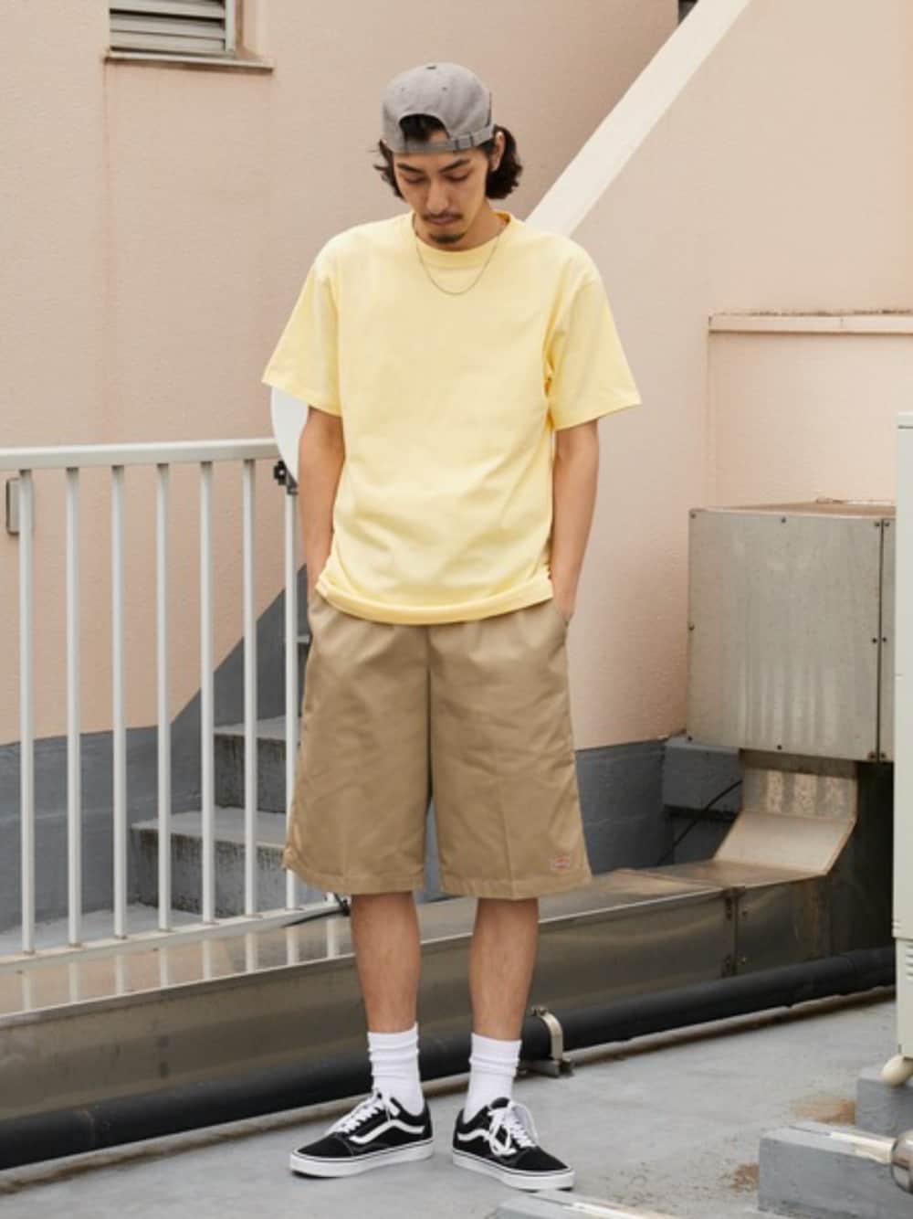 ホワイト系のタンクトップ、イエロー系のTシャツ/カットソー、ベージュ系のチノパンツを着用したメンズの夏コーディネートの1枚目の写真