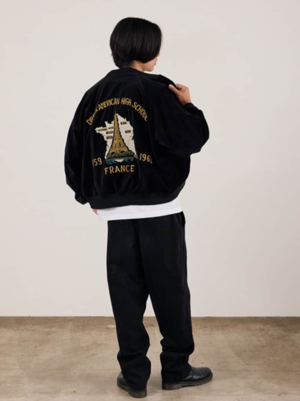 ブラック系のブルゾン、ブラック系のスラックス、ホワイト系のTシャツ/カットソーを着用したメンズの秋コーディネートの1枚目の写真
