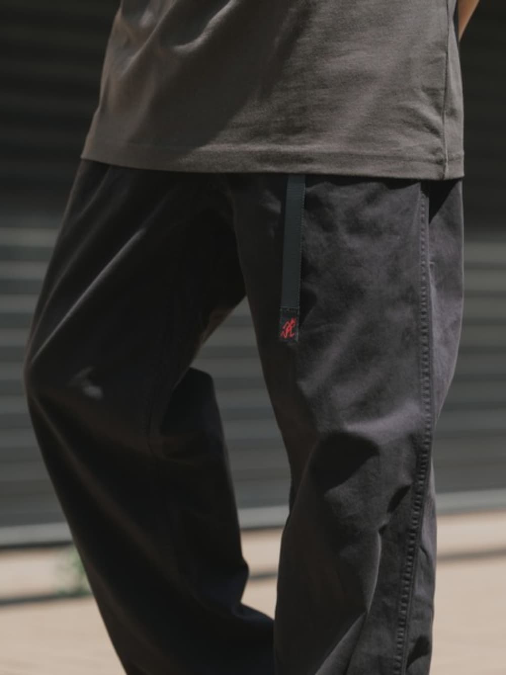ブラック系のチノパンツ、ブラック系のTシャツ/カットソーを着用したメンズの夏コーディネートの1枚目の写真