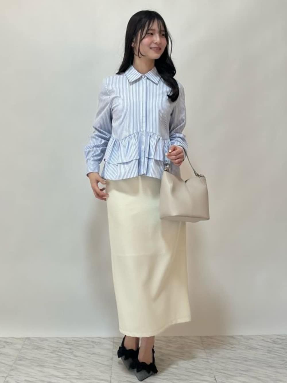 ホワイト系のシャツ/ブラウス、グレー系のパンプス、ベージュ系のスカートを着用したレディースの春コーディネートの1枚目の写真