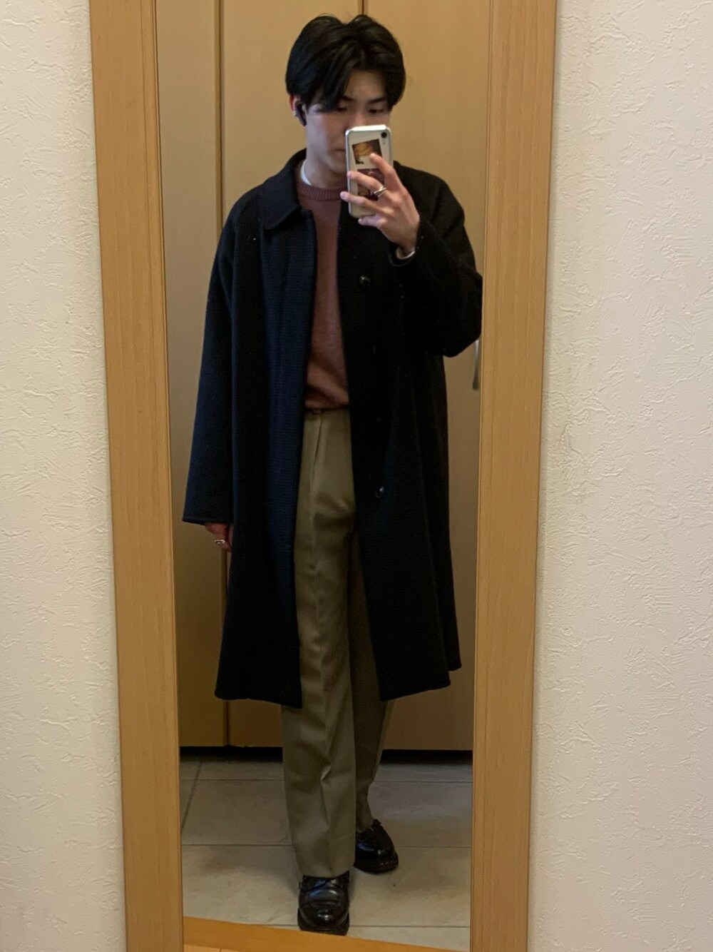 ホワイト系のTシャツ/カットソー、ブラウン系のステンカラーコート、ベージュ系のスラックスを着用したメンズの冬コーディネートの1枚目の写真