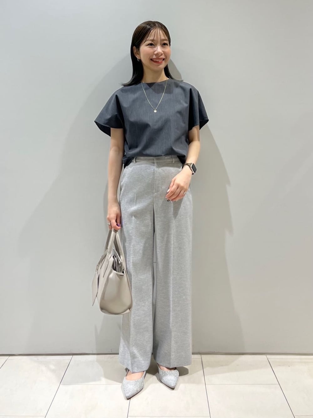 グレー系のシャツ/ブラウス、グレー系のスーツパンツ、グレー系のショルダーバッグを着用したレディースの夏コーディネートの1枚目の写真