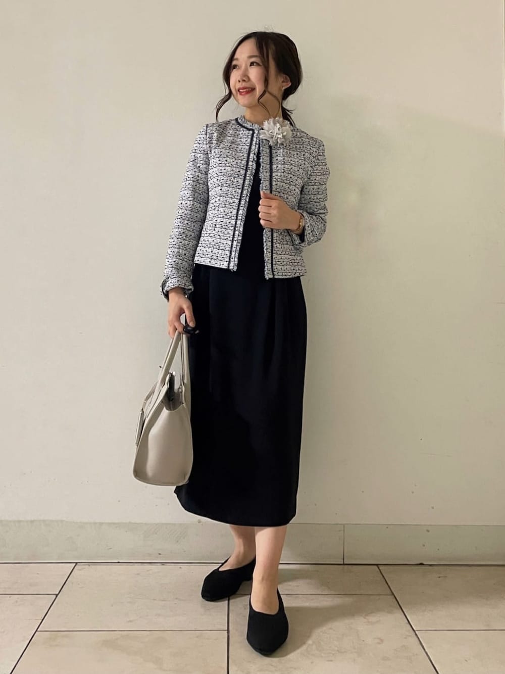 ブルー系のノーカラージャケット、ブラック系のワンピース、グレー系のショルダーバッグを着用したレディースの春コーディネートの1枚目の写真