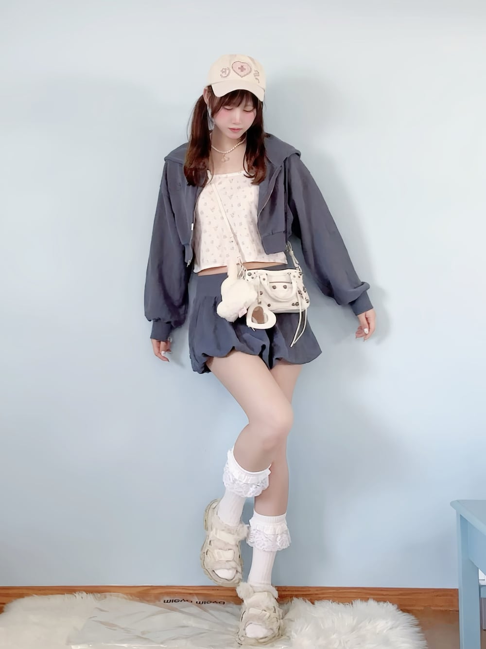 ブルー系のスカート、ブルー系のパーカー、ホワイト系のキャミソールを着用したレディースの春コーディネートの1枚目の写真