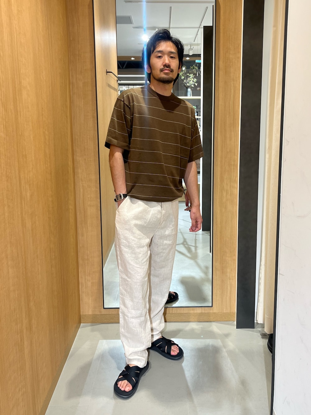 ブラウン系のニット/セーター、ホワイト系のその他パンツ、ブラック系のサンダルを着用したメンズの春コーディネートの1枚目の写真