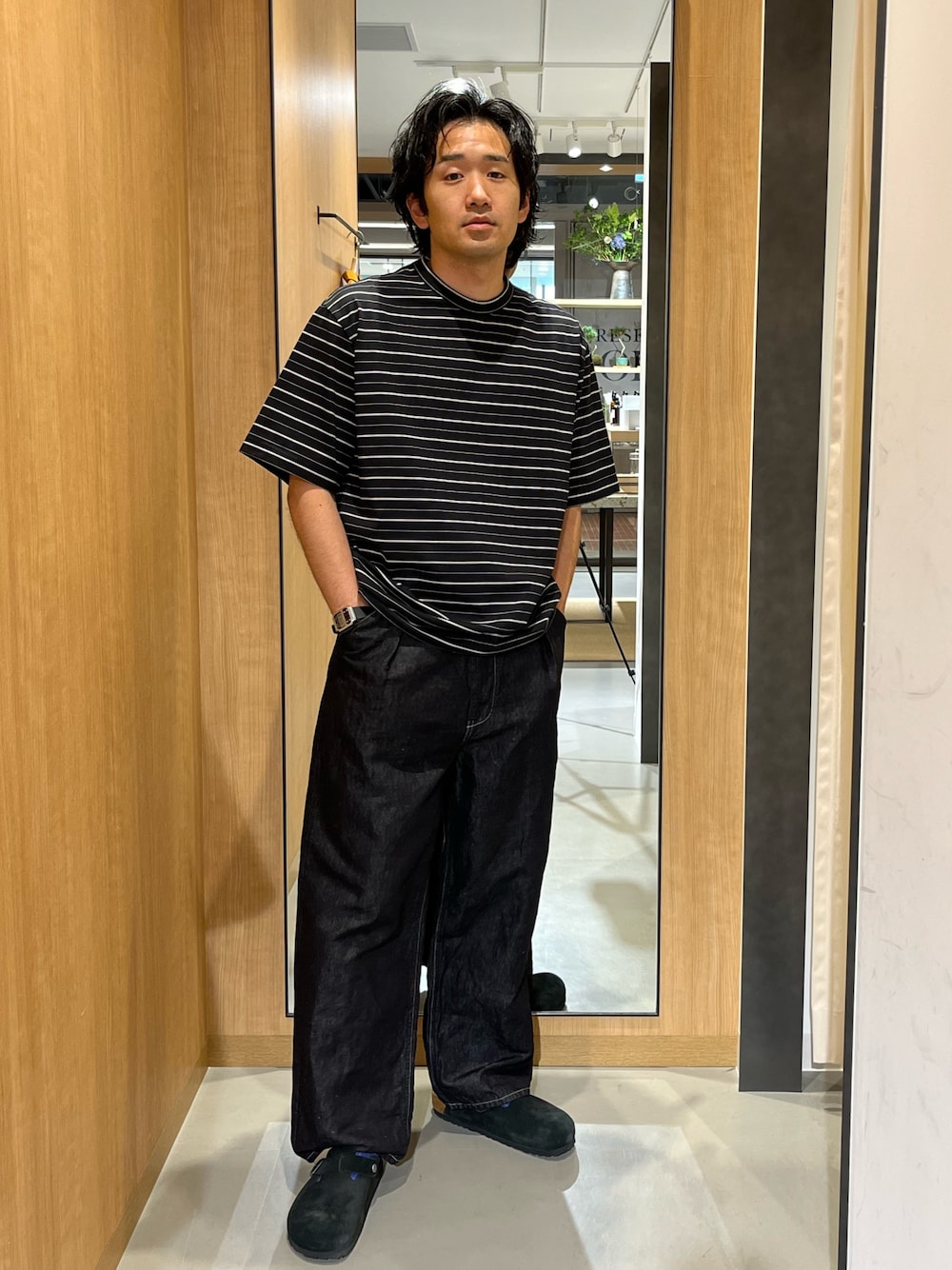 ブラック系のTシャツ/カットソー、ブラック系のデニムパンツ、ブラック系のサンダルを着用したメンズの夏コーディネートの1枚目の写真