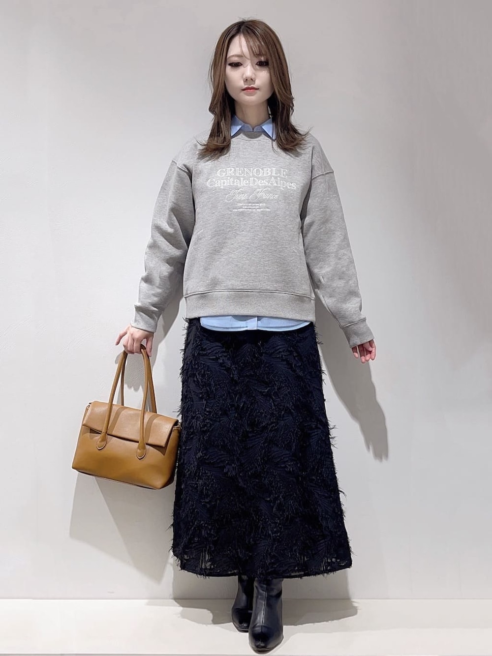 グレー系のスウェット、ブルー系のシャツ/ブラウス、ブラック系のスカートを着用したレディースの冬コーディネートの1枚目の写真