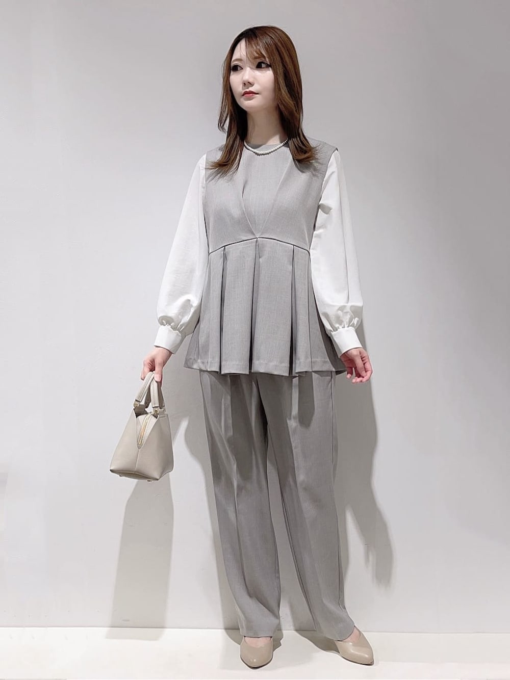 グレー系のシャツ/ブラウス、グレー系のその他パンツ、グレー系のハンドバッグを着用したレディースの冬コーディネートの1枚目の写真