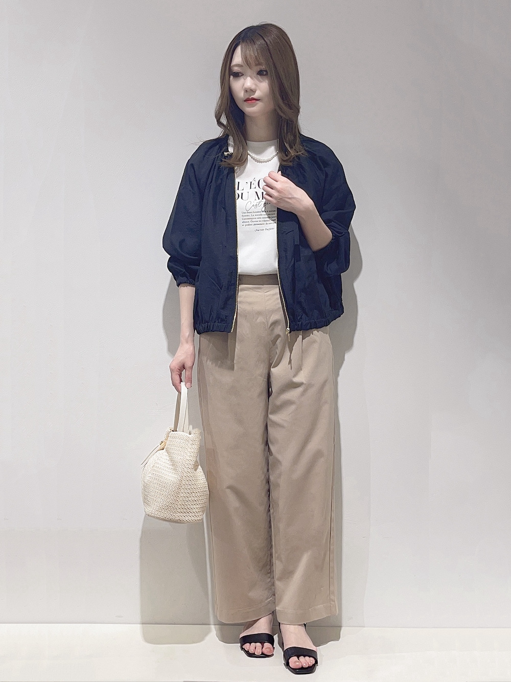 ホワイト系のトートバッグ、ホワイト系のTシャツ/カットソー、ベージュ系のその他パンツを着用したレディースの春コーディネートの1枚目の写真