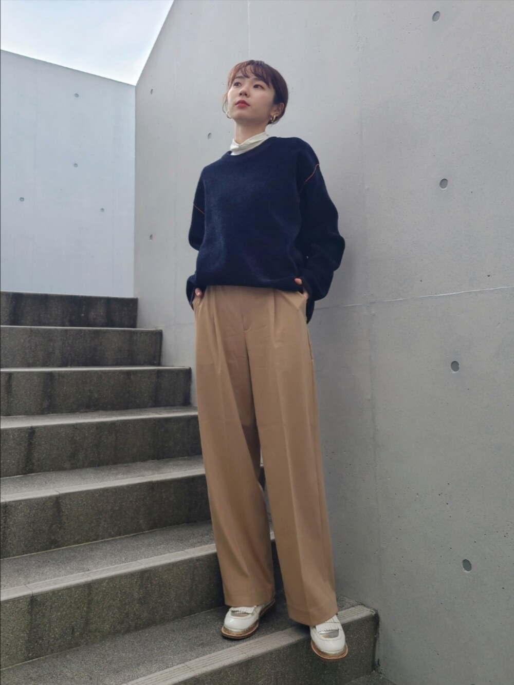 ブルー系のニット/セーター、ベージュ系のパンツ、ホワイト系のその他シューズを着用したレディースの冬コーディネートの1枚目の写真