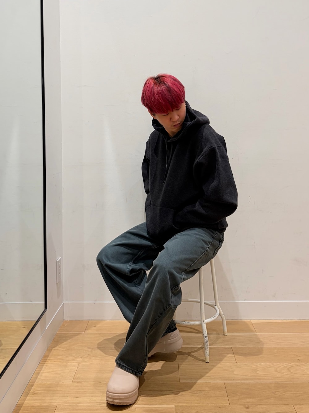グレー系のパーカー、ブルー系のデニムパンツを着用したメンズの秋コーディネートの1枚目の写真