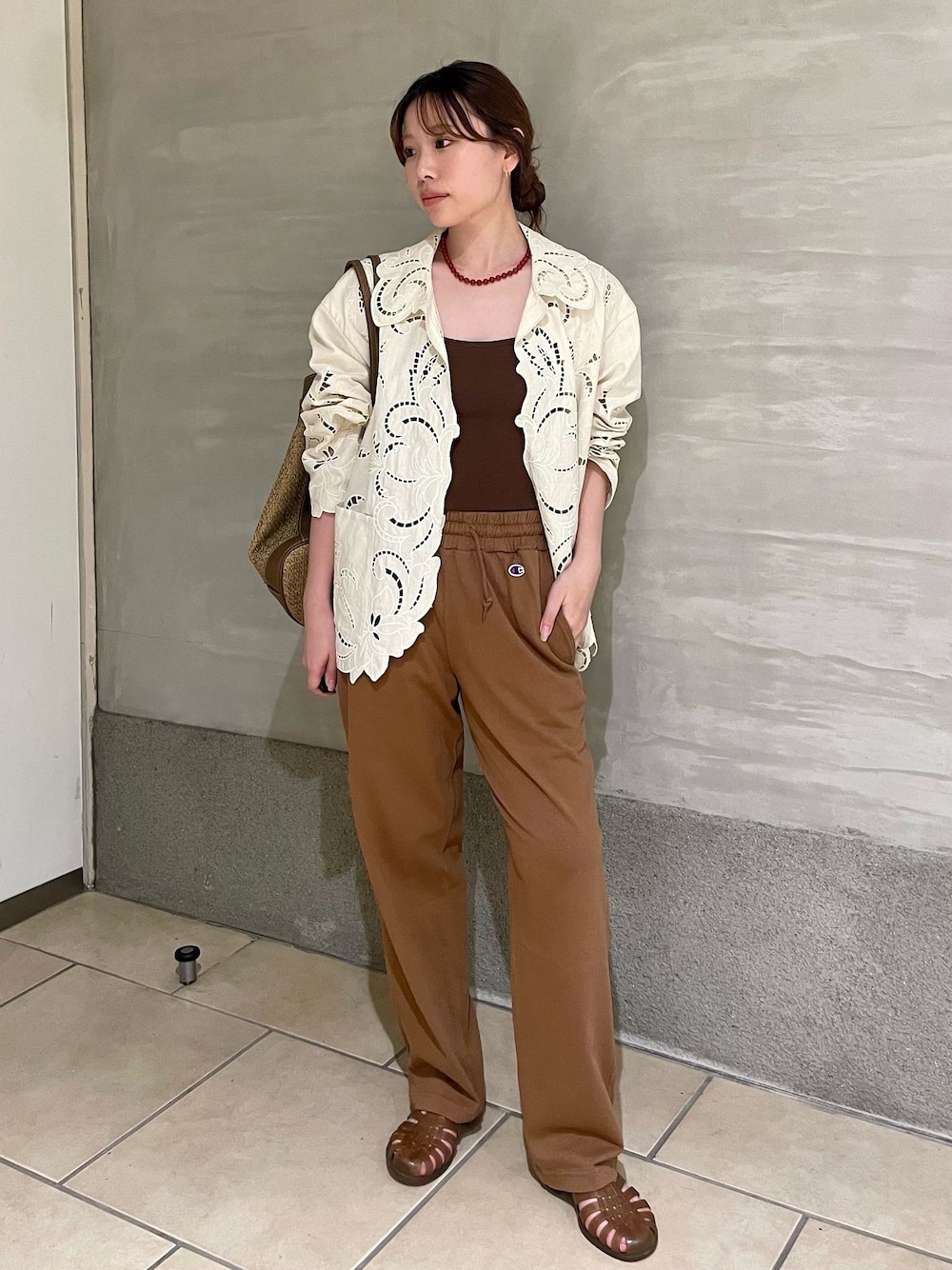 イエロー系のスウェットパンツ、ホワイト系のシャツ/ブラウス、ベージュ系のバックパック/リュックを着用したレディースの夏コーディネートの1枚目の写真