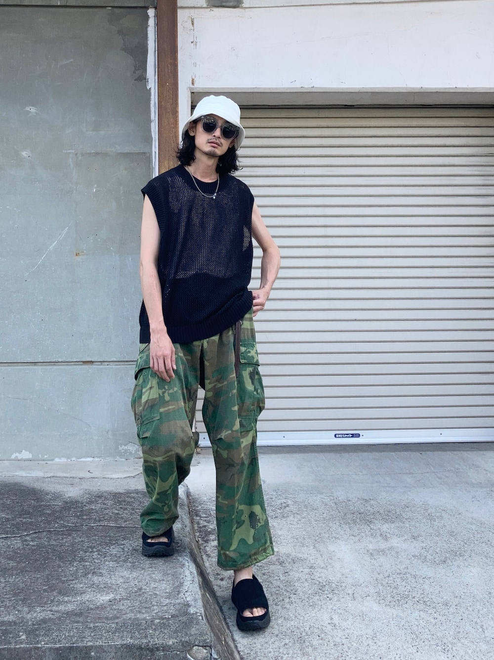 ブラック系のサンダル、ブラック系のニット/セーター、ホワイト系のハットを着用したメンズの夏コーディネートの1枚目の写真