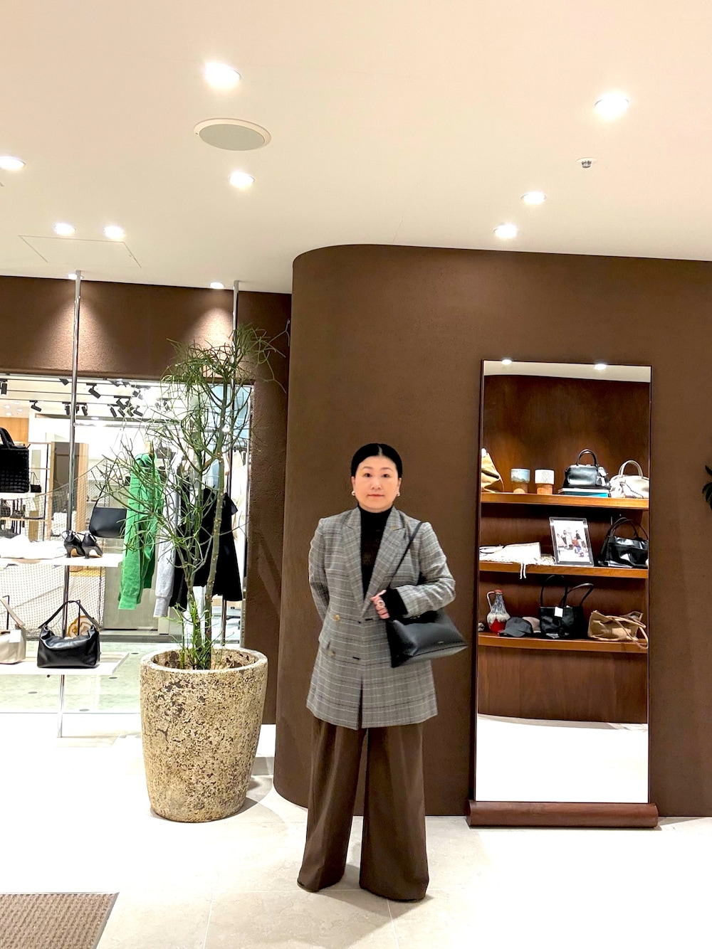 グレー系のテーラードジャケット、ブラウン系のその他パンツ、ブラック系のニット/セーターを着用したレディースの秋コーディネートの1枚目の写真