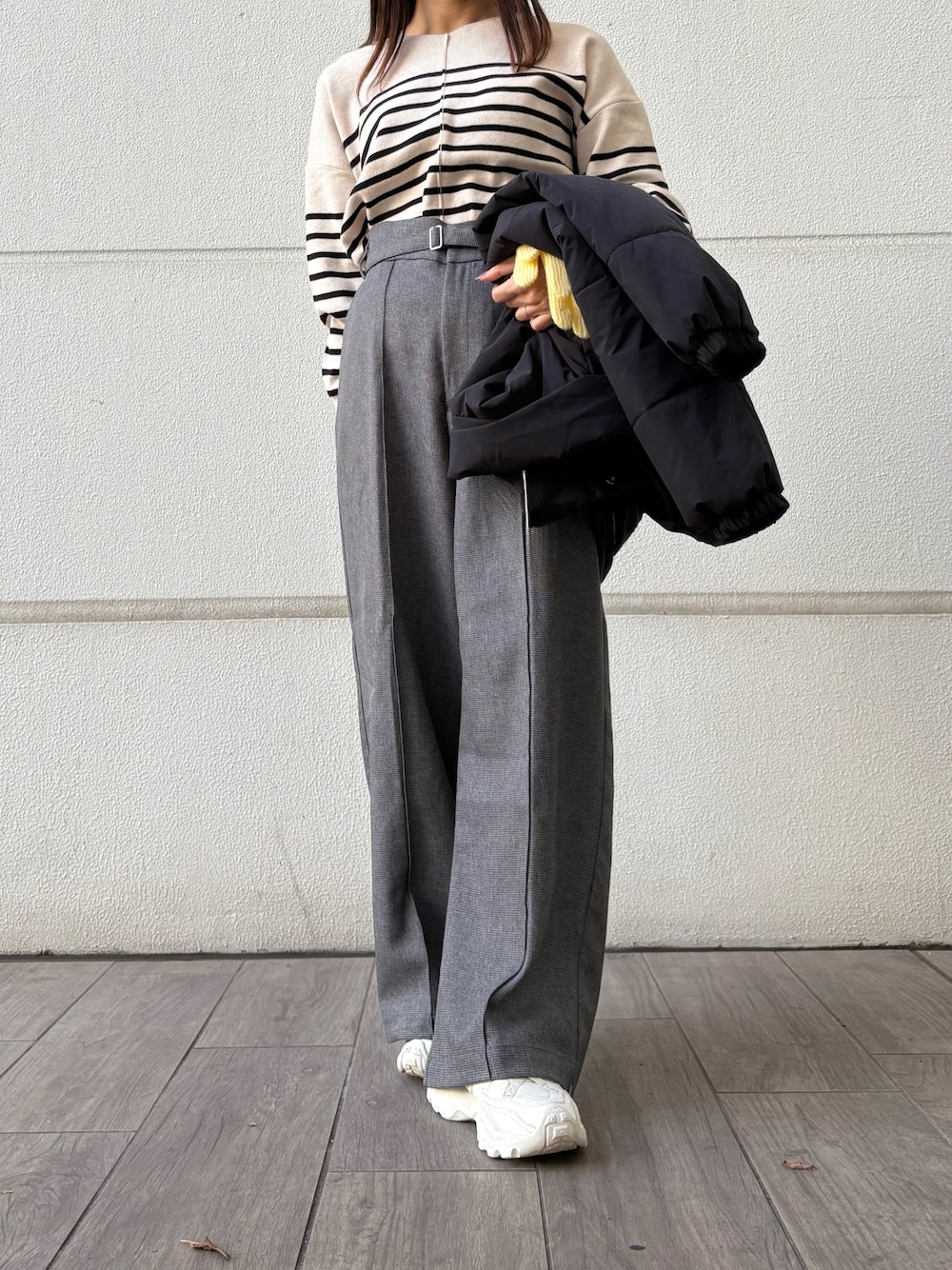 ホワイト系のニット/セーター、グレー系のその他パンツ、ブラック系のダウンジャケット/コートを着用したレディースの冬コーディネートの1枚目の写真