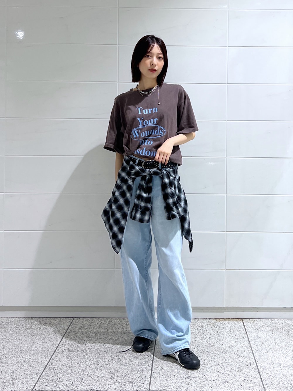 ブラウン系のTシャツ/カットソー、ブラック系のスニーカー、ブラック系のベルトを着用したレディースの秋コーディネートの1枚目の写真