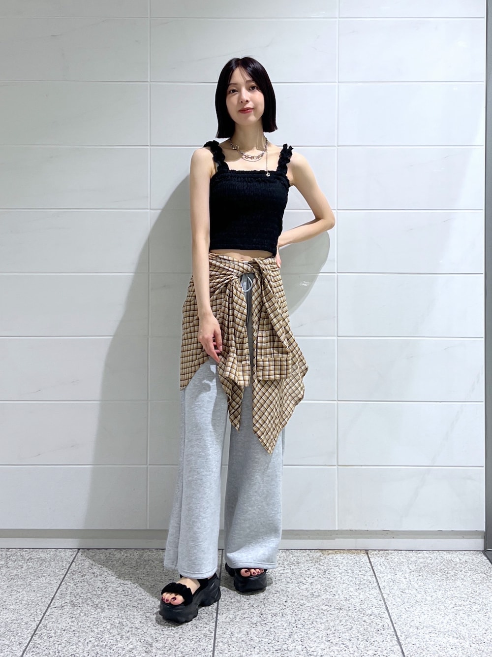 ブラック系のサンダル、イエロー系のシャツ/ブラウス、ブラック系のタンクトップを着用したレディースの夏コーディネートの1枚目の写真