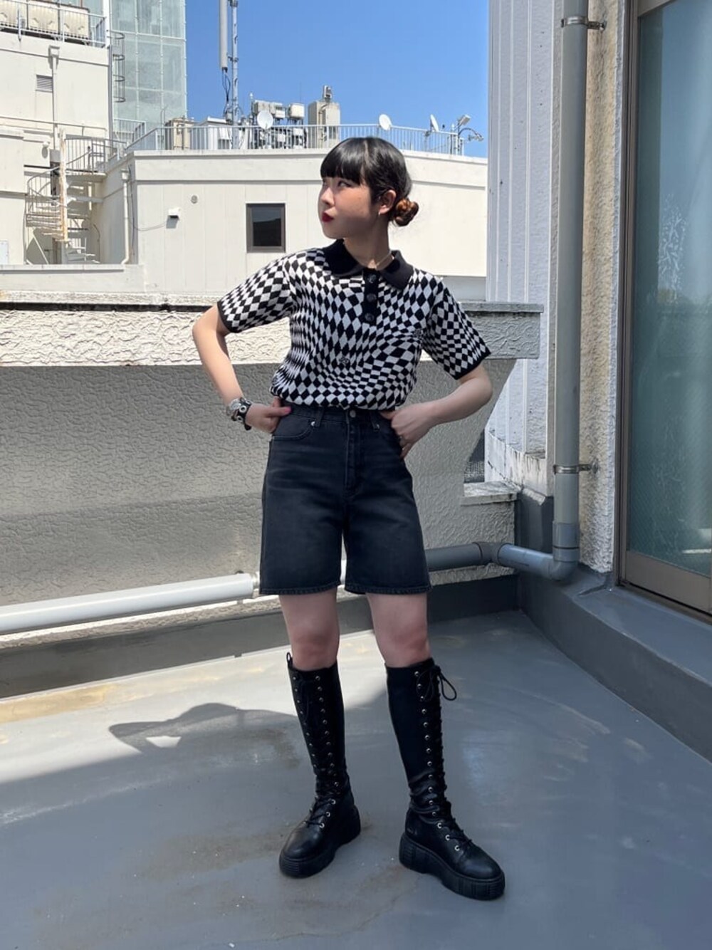 ブラック系のブーツ、ブラック系のニット/セーター、ブラック系のデニムパンツを着用したレディースの春コーディネートの1枚目の写真