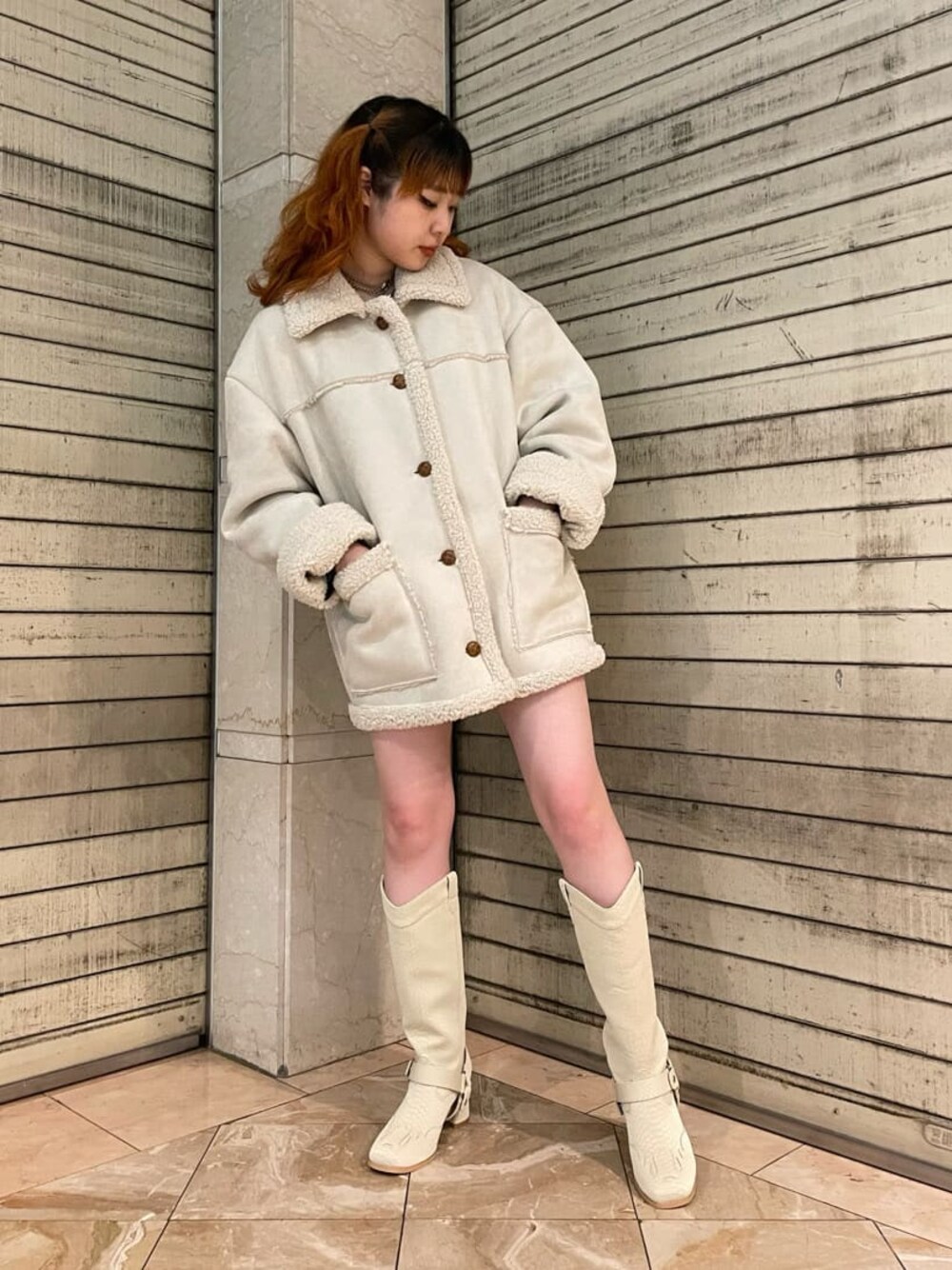 グリーン系のブーツ、ホワイト系のムートンコートを着用したレディースの夏コーディネートの1枚目の写真