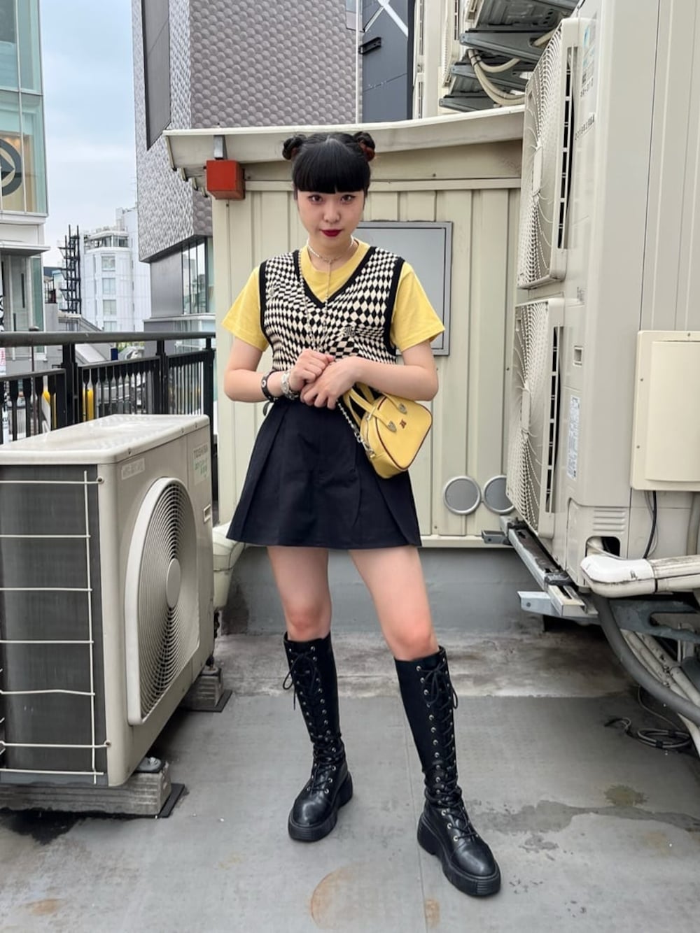 ブラック系のブーツ、ブラック系のニット/セーター、イエロー系のTシャツ/カットソーを着用したレディースの夏コーディネートの1枚目の写真