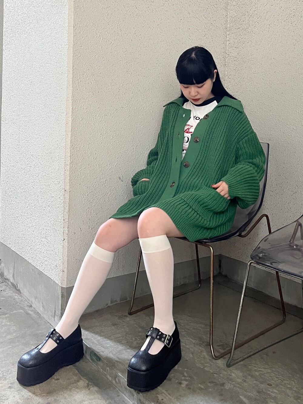 グリーン系のカーディガン/ボレロ、ホワイト系のTシャツ/カットソーを着用したレディースの秋コーディネートの1枚目の写真