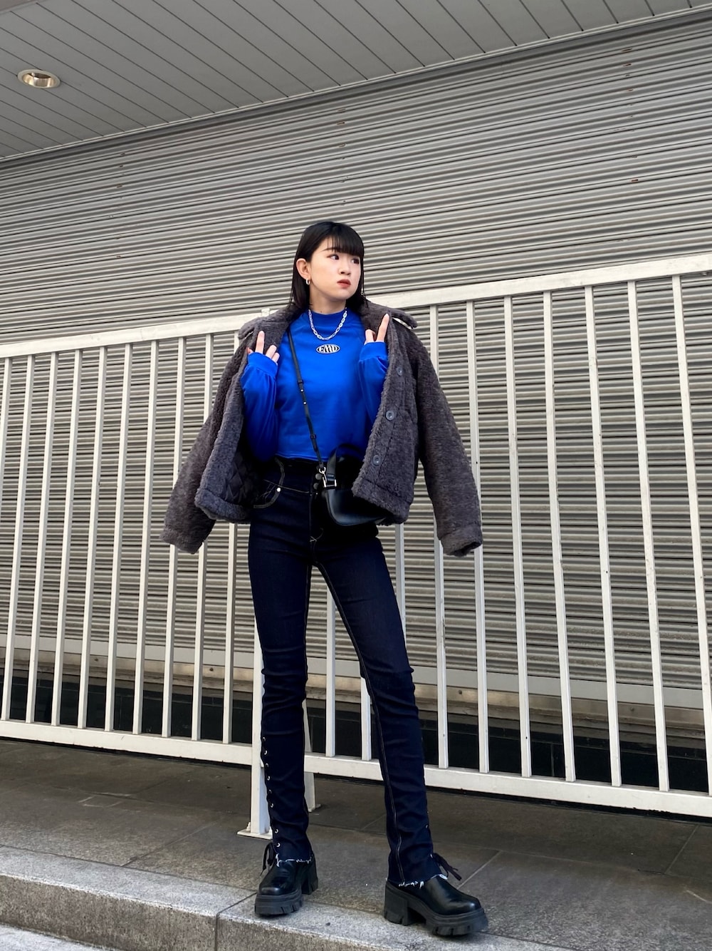 ブルー系のデニムパンツ、ブラック系のブーツ、ブルー系のスウェットを着用したレディースの冬コーディネートの1枚目の写真